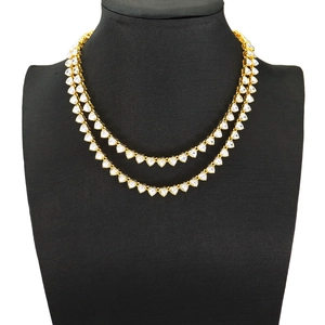 Detail of double-layer gold chain necklace featuring sparkling heart-shaped zircon stones