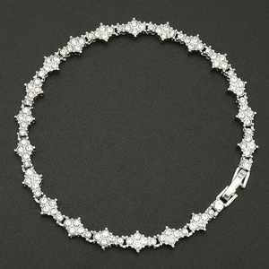 Détail de la chaîne tennis fleur de croix argentée avec zircons étincelants et fermoir