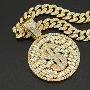 Gros plan d'une chaîne cubaine dorée avec pendentif médaillon signe dollar serti de strass