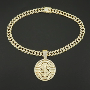 Gros plan sur la chaîne cubaine dorée et pendentif rond dollar serti de diamants hip-hop