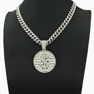 Détail d'un collier chaîne cubaine argentée avec pendentif dollar serti sur buste noir