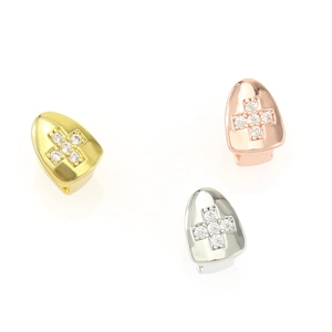 Detail of single tooth grillz with cross pattern zircon stones in gold and silver finish