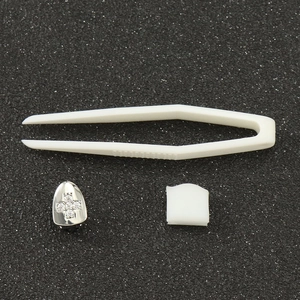 Single silver tooth grillz with cross zircon inlay, including tweezers and silicone bar