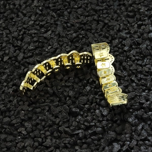 Vista macro di denti hip hop placcati oro con motivi a stella su pietre nere