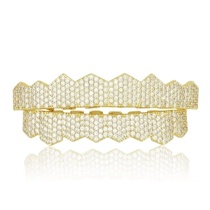 Vue macro de grillz hip hop dorés avec rangées de zircons cubiques et reflet net sur fond