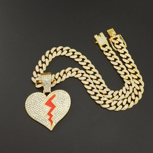 Détail de la chaîne cubaine hip-hop en or avec un grand pendentif cœur brisé givré