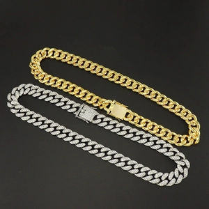 Detail of 15mm thick Cuban link chains in gold finish and silver iced out rhinestones