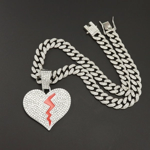 Détail macro du pendentif hip hop cœur brisé avec émail éclair rouge sur chaîne cubaine