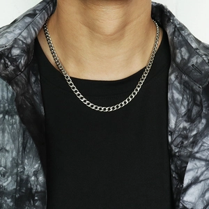 Close-up of silver stainless steel curb chain necklace worn over a casual black shirt