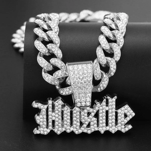 Dettaglio della catena cubana d'argento e ciondolo HUSTLE con strass scintillanti incastonati