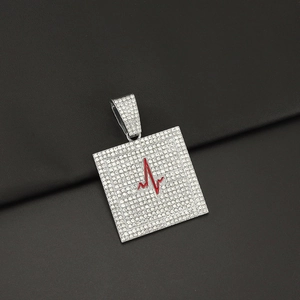 Detailaufnahme des silbernen iced-out Anhängers mit rotem EKG Herzschlag Symbol