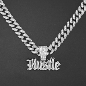 Vista macro di una catena cubana hip hop argentata con ciondolo Hustle in diamanti