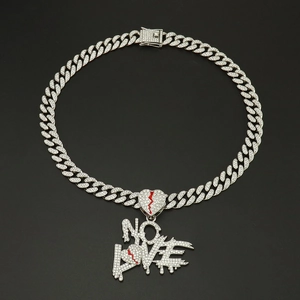 Macro detail of iced out Cuban chain with NO LOVE broken heart pendant for hip hop style