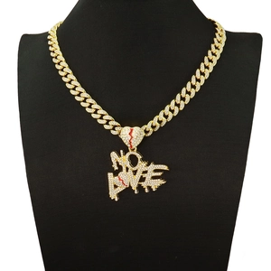 Macro detail of iced out gold cuban chain necklace with crystal no love heart pendant