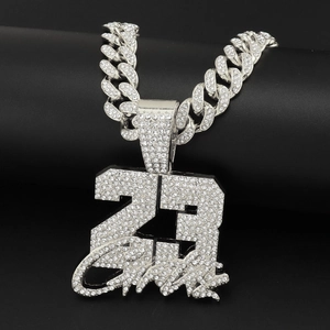 Detailed macro view of iced out number 23 pendant necklace with silver cuban chain