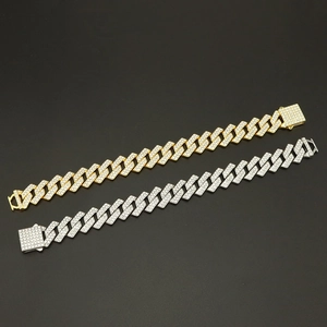 Dettaglio di bracciali cuban link da 15mm in oro e argento con fibbie con diamanti
