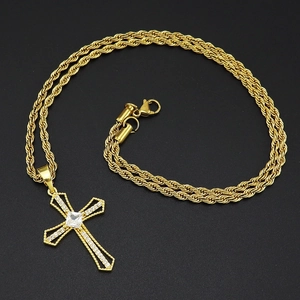 Collana a corda dorata con ciondolo a croce incastonato di zirconi su sfondo nero