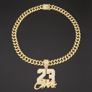Macro shot of gold-plated iced-out Cuban chain and iced number 23 pendant with signature