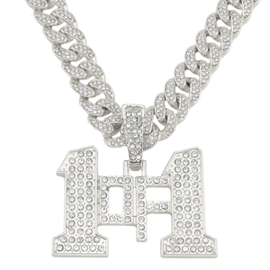 Dettaglio macro del ciondolo numero 11 in argento con zirconi su una catena a maglia cubana