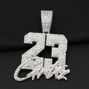Macro shot of silver hip hop pendant with number 23 and cursive iced out details