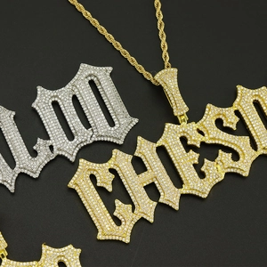 Macro shot of iced-out gold 100 and Chase pendants with twisted chain in hip-hop style