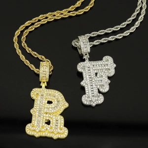 Gros plan des pendentifs lettre hip-hop glacés avec pavage dense et chaîne de torsion