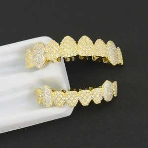 Macro shot of hip hop gold teeth grillz with micro pave zircon stones on black background