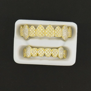 Macro view of gold-plated hip hop grillz set with cubic zirconia in a white display box