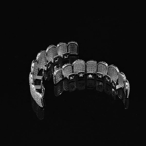 Macro shot of silver hip hop grillz featuring star cutout detail and iced out zircon stones