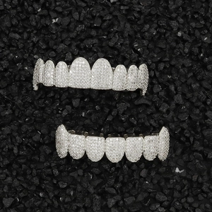 Hip hop silver grillz set with sparkling white zircons on a textured black rock background