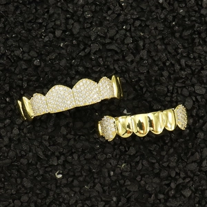 Vue détaillée du set de grillz hip hop doré serti de zircons sur fond de roche noire