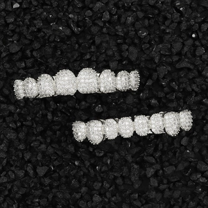 Hip hop style silver tooth grillz set with pavé stones on black stone background
