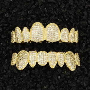 Macro shot of gold hip hop grillz set encrusted with sparkling white cubic zirconia stones