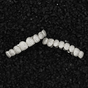 Macro shot of silver hip hop grillz set with paved white zircon stones on black stones