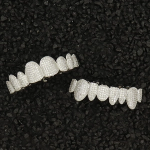 Silver hip hop grillz set with cubic zirconia pave stones on black gravel background