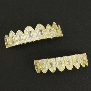 Close-up of hip hop gold grillz set with pavé white cubic zirconia on black leather