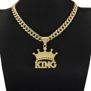 Makroaufnahme von KING-Kronenanhänger mit Strass auf goldener Panzerkette im Hip-Hop-Stil