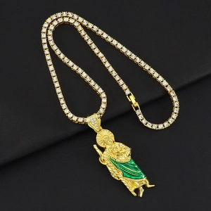 Macro detail of gold San Judas pendant with green enamel and crystal tennis chain