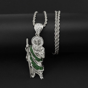 Macro shot of silver St. Jude pendant with green and white zircons on a rope chain