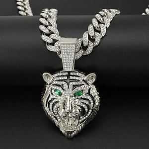 Détail du pendentif tigre hip-hop avec yeux en pierre verte et chaîne cubaine sertie