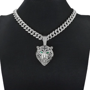 Collier tête de tigre argenté avec yeux verts et strass sur une chaîne cubaine