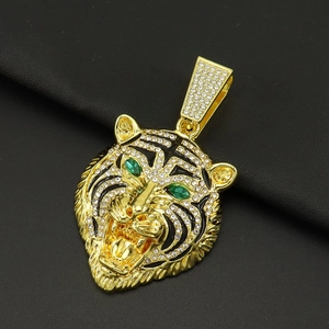 Vue détaillée du pendentif tête de tigre doré avec pavé de zircons et yeux verts