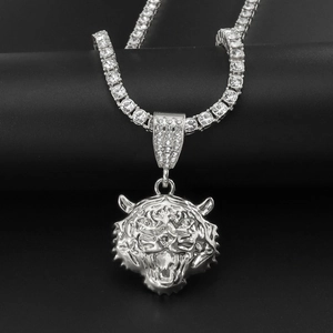 Gros plan du pendentif tête de tigre en argent incrusté de zircons sur chaîne tennis