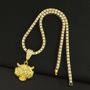 Détail du pendentif tête de tigre plaqué or 3D avec zircons sur une chaîne tennis