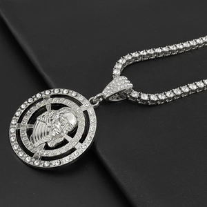 Detail showing hip-hop Jesus pendant with tennis chain on black leather background