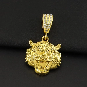 Détail macro du pendentif tête de tigre 3D doré avec pavé de cristaux sur cuir noir