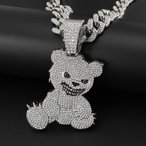 Macro shot of silver hip-hop bear pendant with iced-out crystals on a thick Cuban chain