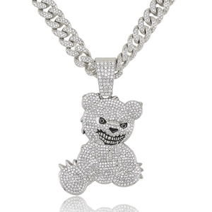 Macro shot of silver Cuban link chain and diamond-encrusted angry bear pendant