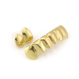 Macro view of shiny gold hip hop grillz set featuring six-tooth bar and two single fangs