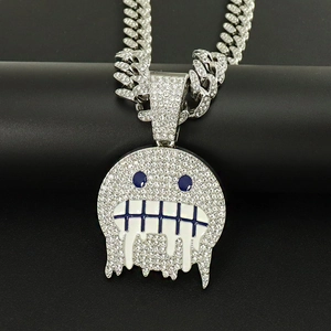 Dettaglio macro del ciondolo emoji con strass e catena cubana in argento lucido